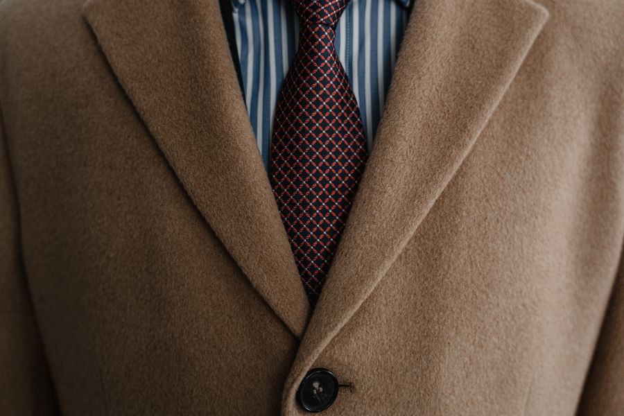 Primer plano de abrigo de lana con corbata estampada