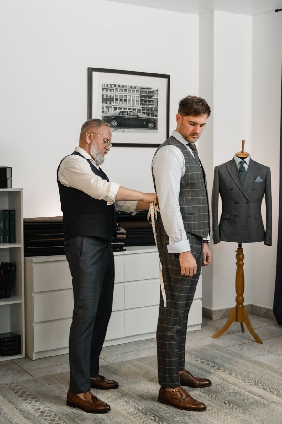 Sastre ajustando el traje de un cliente en el atelier